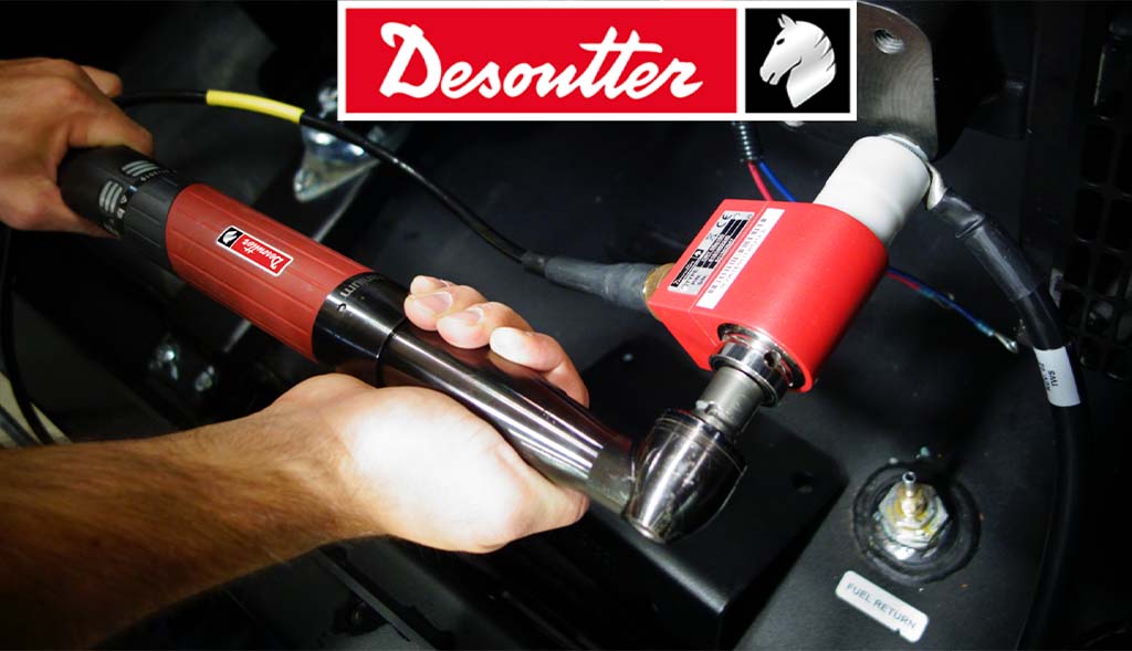 A worker's hands using a Desoutter brand electric screwdriver to fasten components in an Air Centers of Florida manufacturing or assembly setting.