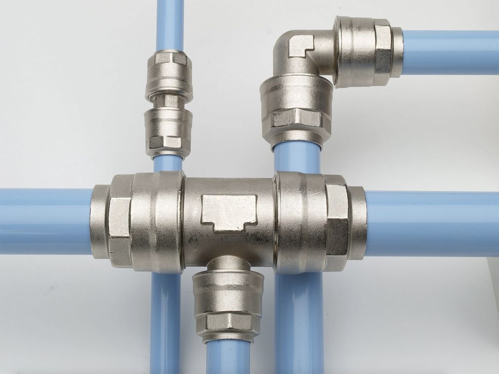 Complex network of metal and blue plastic pipes connected with Air Centers of Florida fittings on a gray background.